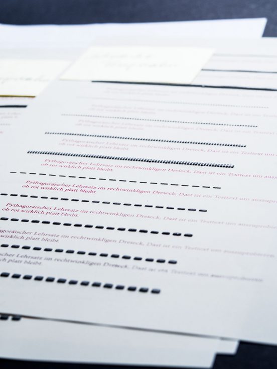 Close up of swell paper with black, 3D lines and flat red writing.